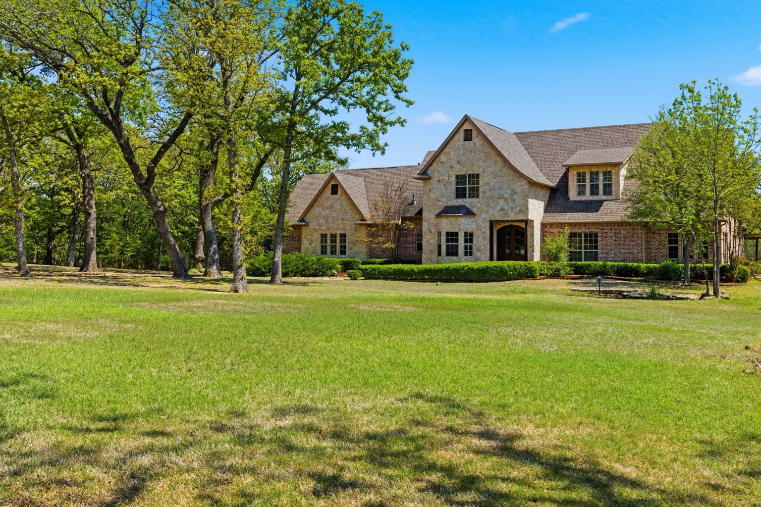 Large Oklahoma home exterior surrounded by mature trees
